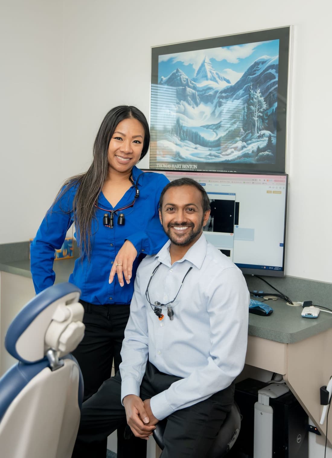 Dr. Bautista and Dr. Uddaraju beside the treatment chair in the BU Dental operatory
